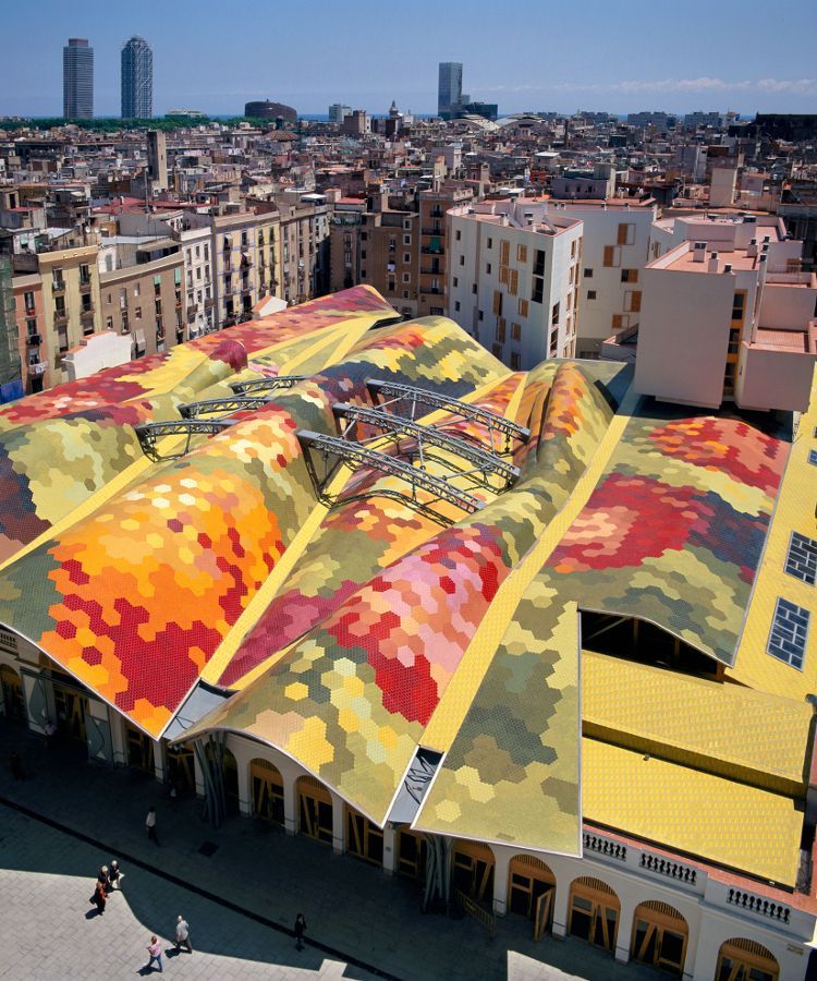 Aerial view of Mercat de Santa Caterina featuring its colorful mosaic roof and the surrounding Barcelona cityscape.